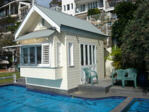 Bauhaus Constructions small boat house, built to the rear on the waterfront in Birchgrove, which the owner uses as a pool house, with a small box , out cantilevered to leave it over the pool, providing a day bed on the inside and adjustable shutters to the outside.